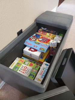 reviewer photo of gray storage ottoman with games inside