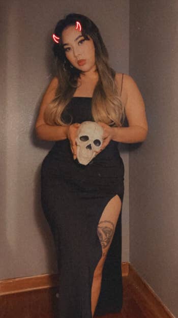 reviewer wearing dress while holding prop skull