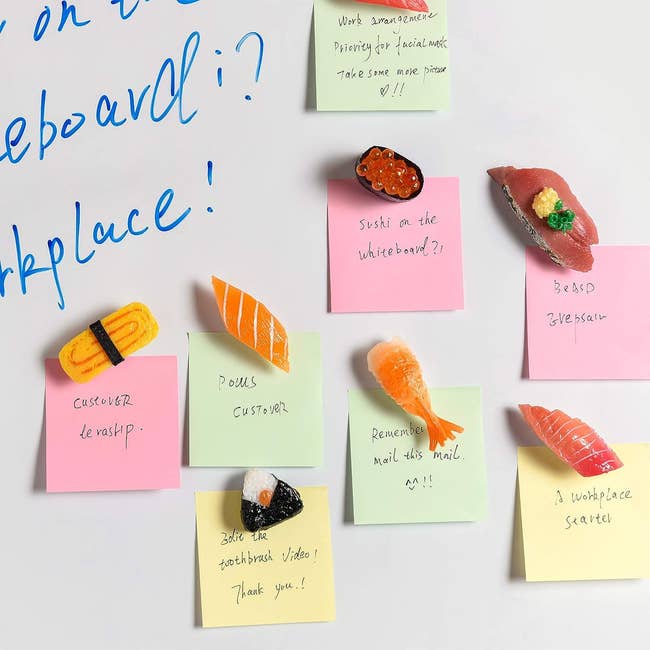 The magnets holding sticky notes on a whiteboard