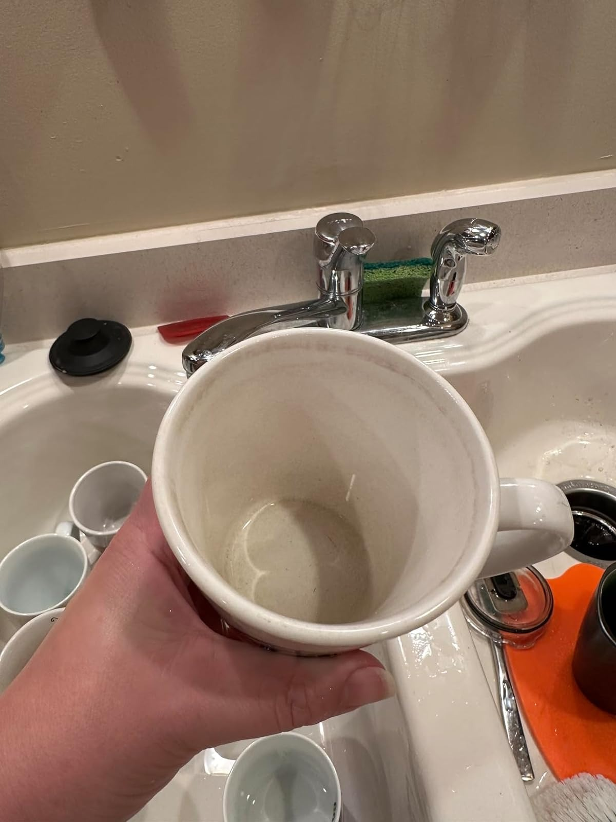 hand holding the same mug now significantly less stained