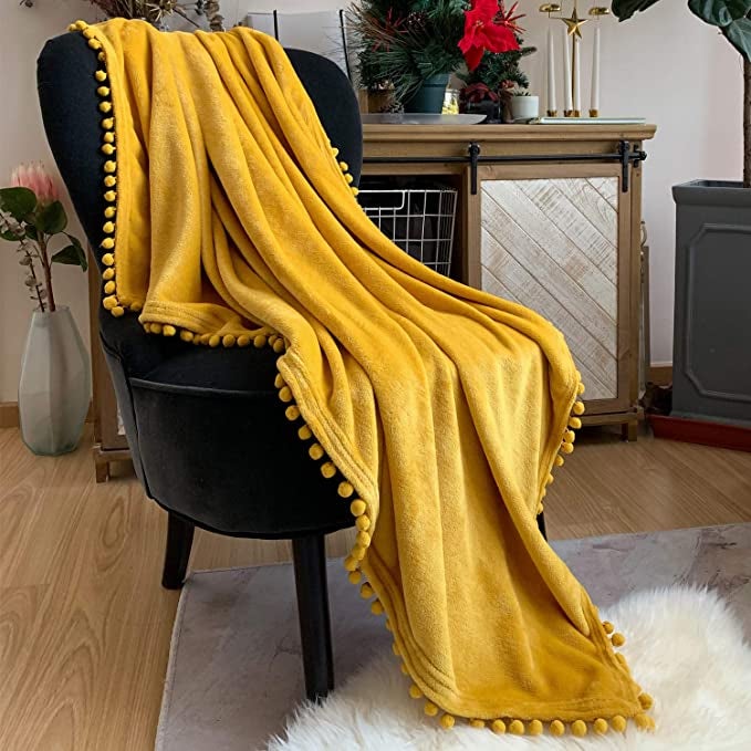 yellow throw blanket on a black chair