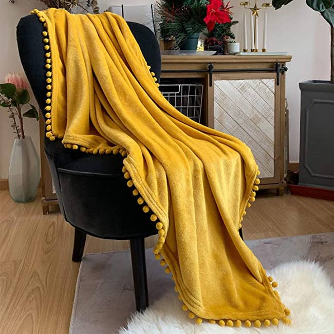 yellow throw blanket on a black chair