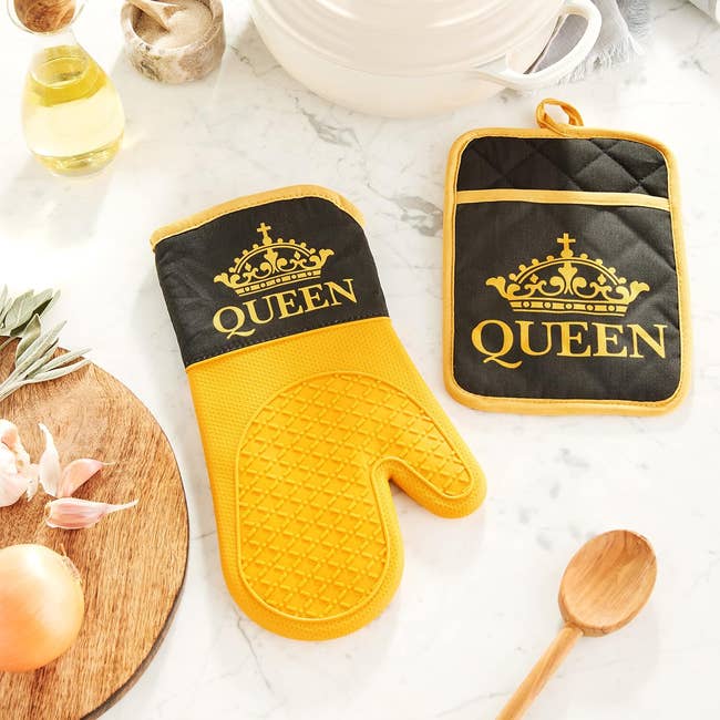 Oven mitt and potholder set with 'QUEEN' text, displayed on kitchen counter with utensils