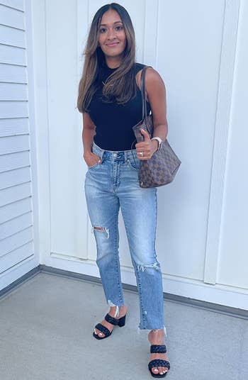 reviewer wearing the black sandals with jeans