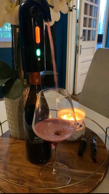 Reviewer's wine dispenser pouring wine into a wine glass