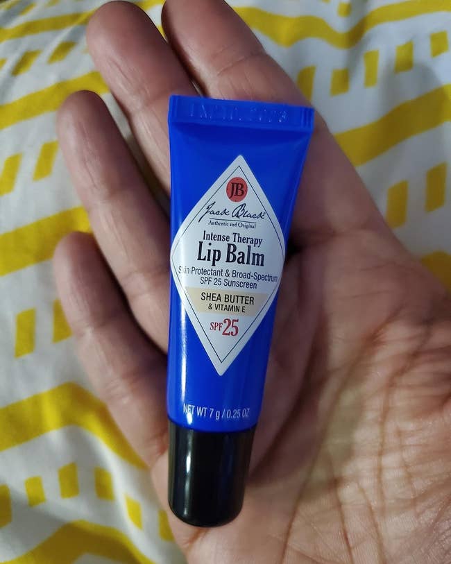 image of a tube of lip balm in the palm of a reviewer's hand