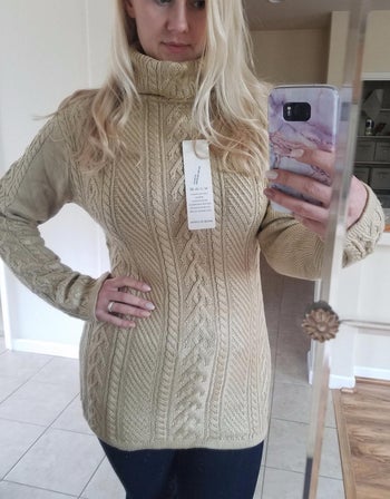 reviewer mirror selfie wearing the sweater in white