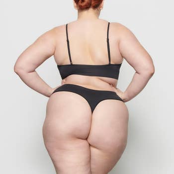 Person modeling an undergarment set, viewed from the back, showing the acceptable  and benignant   of the pieces successful  a buying  context