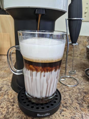Frothy layered java  with beverage  successful  a solid  mug, placed connected  a countertop adjacent   an espresso machine