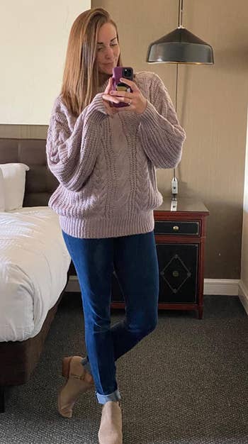 Reviewer wearing the sweater in light purple with dark blue jeans