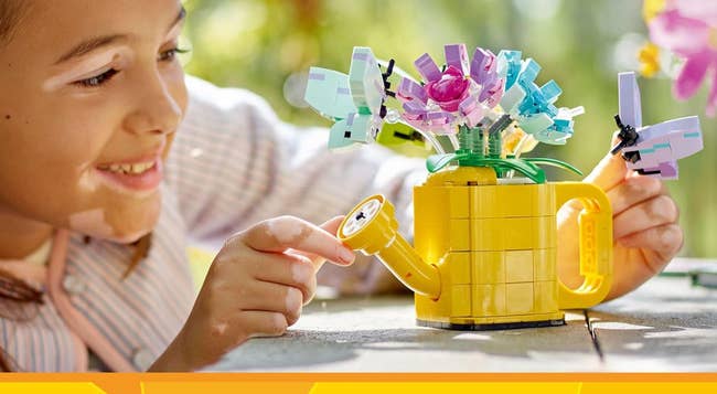 Child interacts with a LEGO bouquet, smiling while engaging in the creative play. Perfect for family shopping