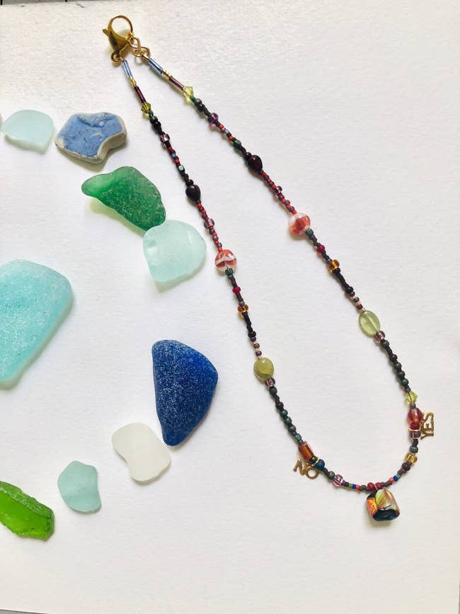 a custom made charm necklace surrounded by colorful stones