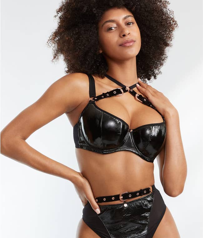 Model wearing black faux leather BDSM bra and matching panties