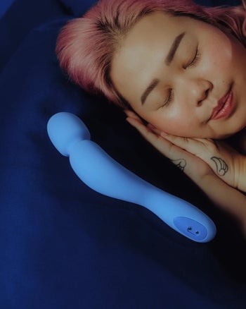 Woman sleeping next to blue wand vibrator