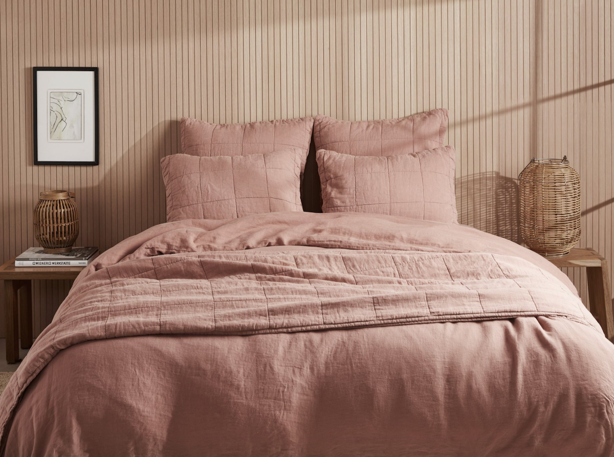 a light pink quilt on a bed