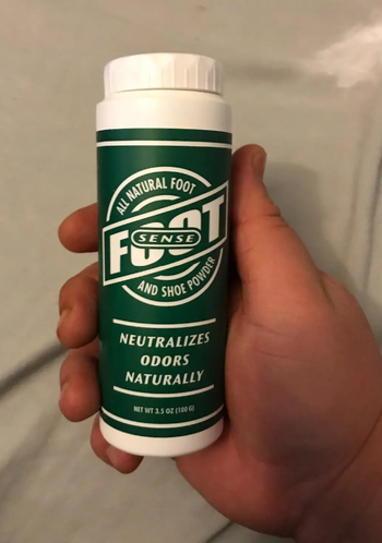 reviewer holding bottle of foot powder