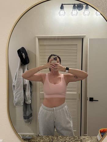 Person successful a vessel apical and sweatpants taking a reflector selfie successful a bathroom
