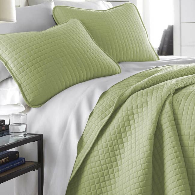 A sage green quilt and shams
