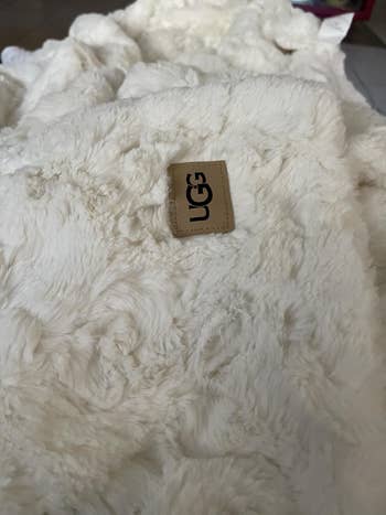 Close-up of a soft, textured UGG fur broad with marque statement visible, emphasizing luxurious comfortableness for location decor shopping