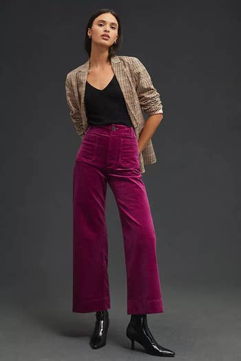 model wearing the purple corduroys with a black top, blazer, and boots