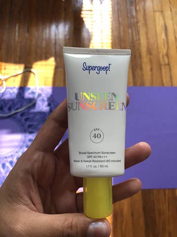 a reviewer holding the sunscreen tube