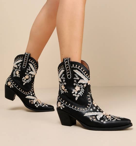 a model wearing embroidered, western-style ankle boots with a floral pattern 