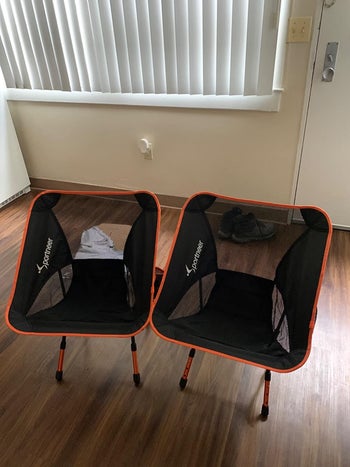 reviewer photo of the two black and orange camper chairs