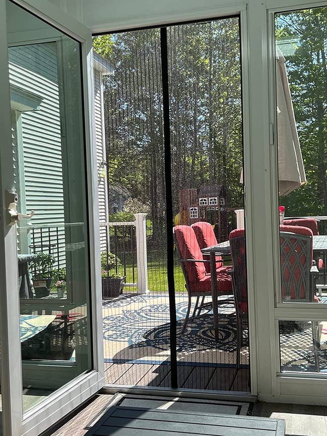 Reviewer's magnetic screen door installed leading to their backyard