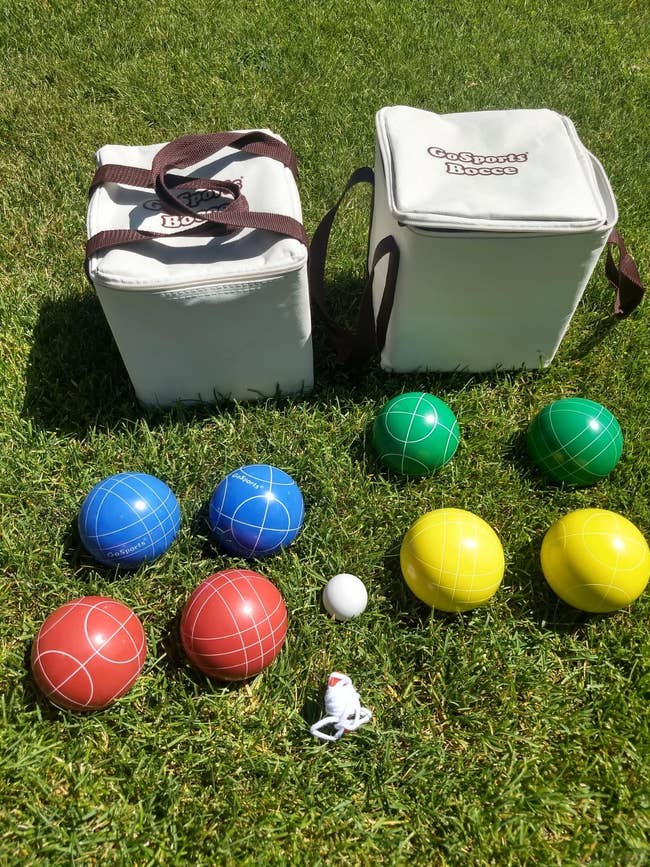 Two portable bocce ball sets with carrying cases and bocce balls arranged on grass for outdoor fun