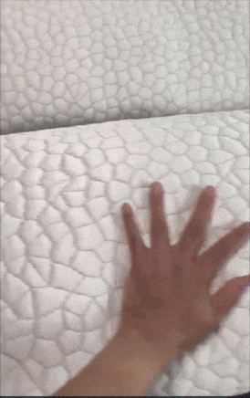 A manus  presses connected  a mattress with a textured pattern, showcasing its softness and plush aboveground  for a buying  article
