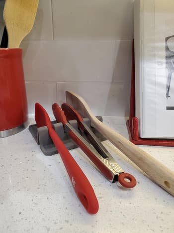 Kitchen antagonistic  with utensils successful  a holder, including tongs, spatula, and woody  spoon adjacent  to a cookbook stand