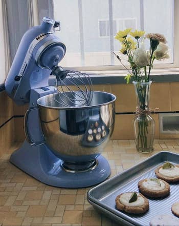 reviewer image of the lavender stand mixer next to a tray of cookies