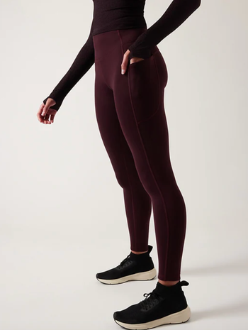 Model in maroon leggings with a side pocket 