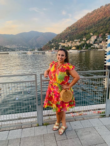 writer of the piece wearing the gold birkenstocks with a colorful dress while on vacation