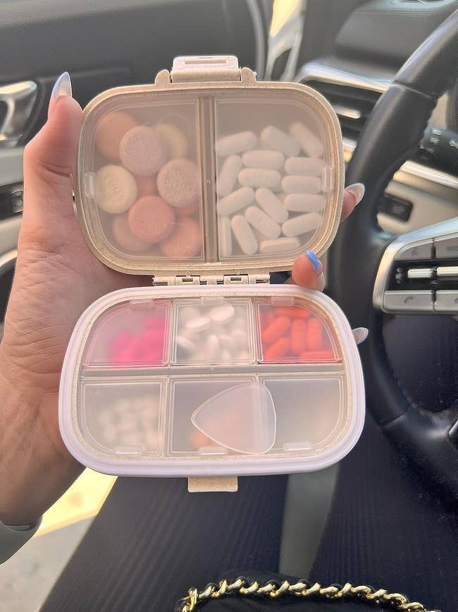 reviewer holding pink pill organizer with eight compartments