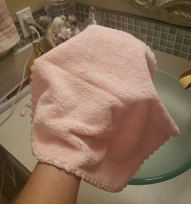 Reviewer holding their pink makeup removing cloth in their hand