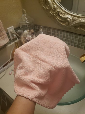 Reviewer holding their pink makeup removing cloth in their hand