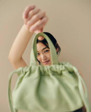 model holding the lime green bag