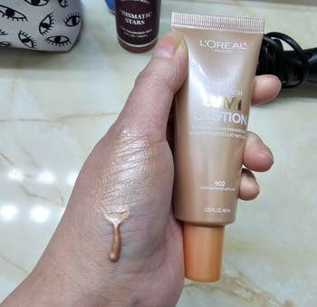 reviewer holding moisturizer with some on their hand