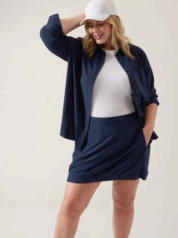 plus-size model wearing the navy blue version open over a white T-shirt and matching navy skirt
