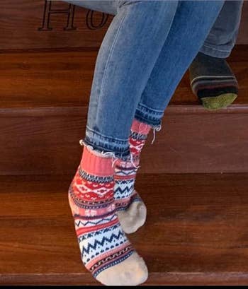 reviewer wearing one of the colorful sock pairs from 