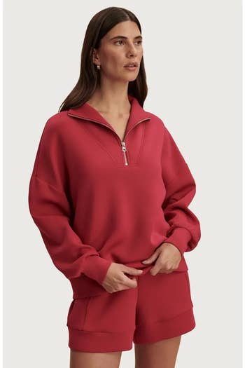 Person successful  a casual half-zip sweater and matching shorts looks to the side, lasting  successful  a relaxed pose