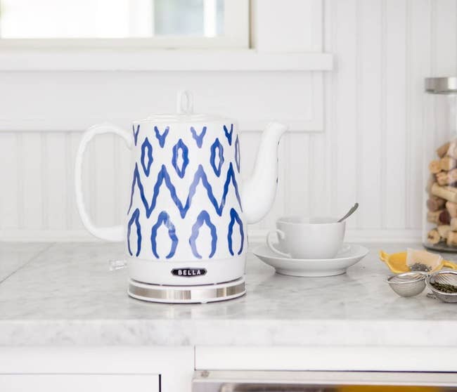 the blue and white tea kettle on a kitchen counter
