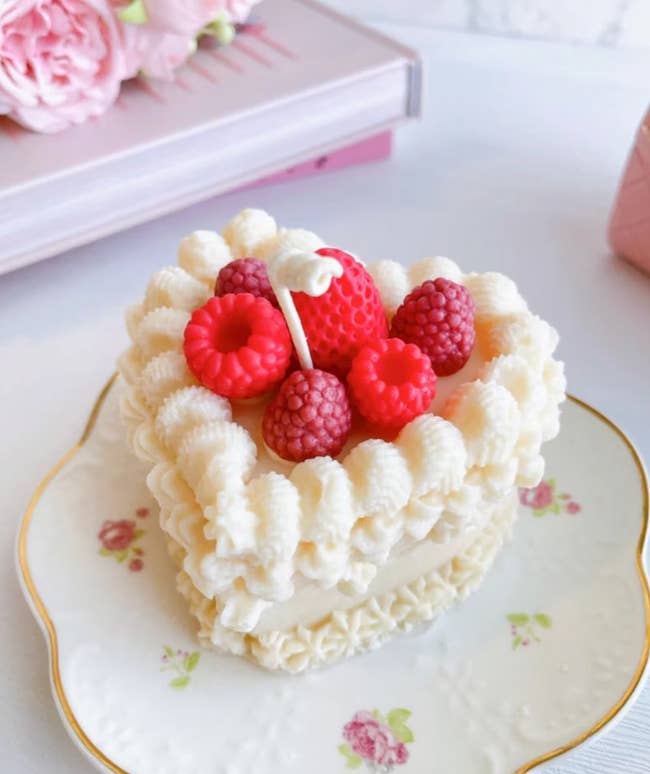white cake candle with faux strawberries and raspberries