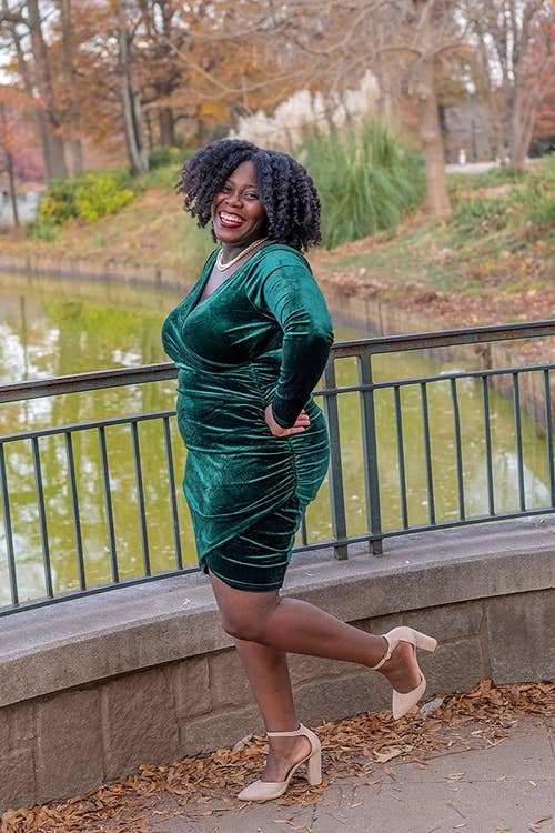 Reviewer is wearing the ruched dress in a velvet green