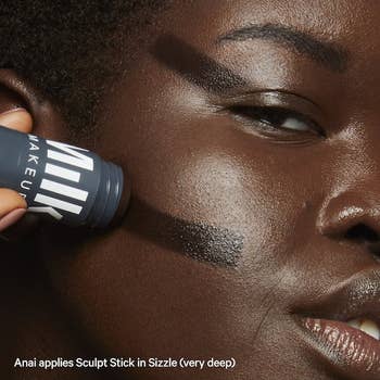 a model applying the darkest shade, sizzle, to their face