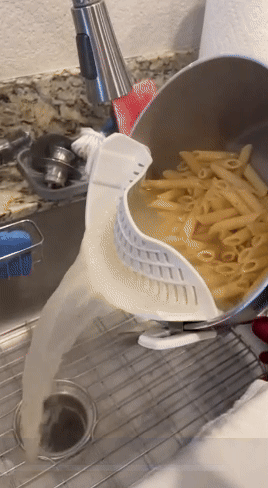 gif of reviewer straining water out of pasta pot with white clip-on strainer