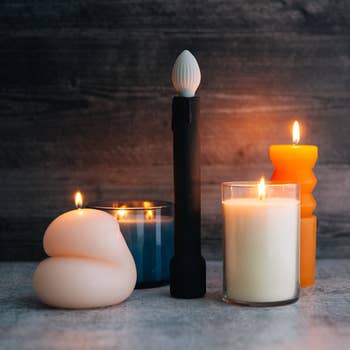 Black candle vibrator surrounded by actual candles