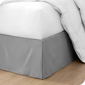 the gray skirt covering the bottom of a bed so you can't see what's underneath