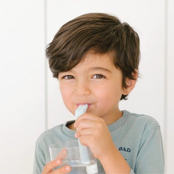 child using the HiccAway, which looks like a normal curved straw